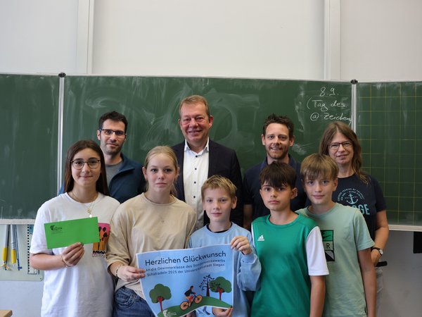 (v.l.) Hendrik Kölsch (DAV), Bürgermeister Steffen Mues, Jan König (Mobilitätsmanager) und Judith Zeller (Klassenlehrerin 7e) überreichen den Hauptpreis an die Schülerinnen und Schüler.