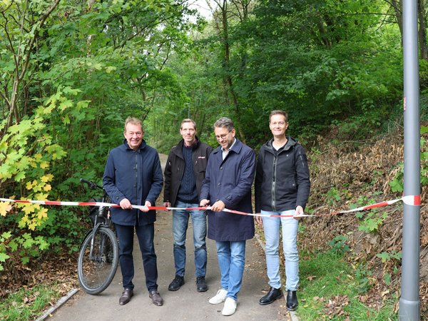 Der Weg ist frei: Stadtbaurat Henrik Schumann (2.v.r.) eröffnet zusammen mit Bürgermeister Steffen Mues (l.), Benjamin Hinkel (2.v.l.) (Abteilungsleiter Straße und Verkehr) sowie Felix Hammerschmidt (r.) (Fahrradbeauftragter) den Geh- und Radweg Am Jähen Hain. (Foto: Stadt Siegen)