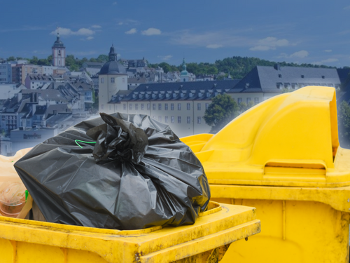 Gefüllte Gelbe Tonnen vor dem Siegener Stadtpanorama (Symbolbild)