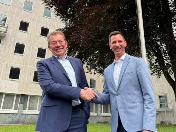 Bürgermeister Steffen Mues und Landrat Andreas Müller vor dem Seitentrakt des Telekom-Gebäudes, das künftig die neue Anlaufstelle für Ausländerangelegenheiten im Kreis sein wird (Foto: Kreis Siegen-Wittgenstein)