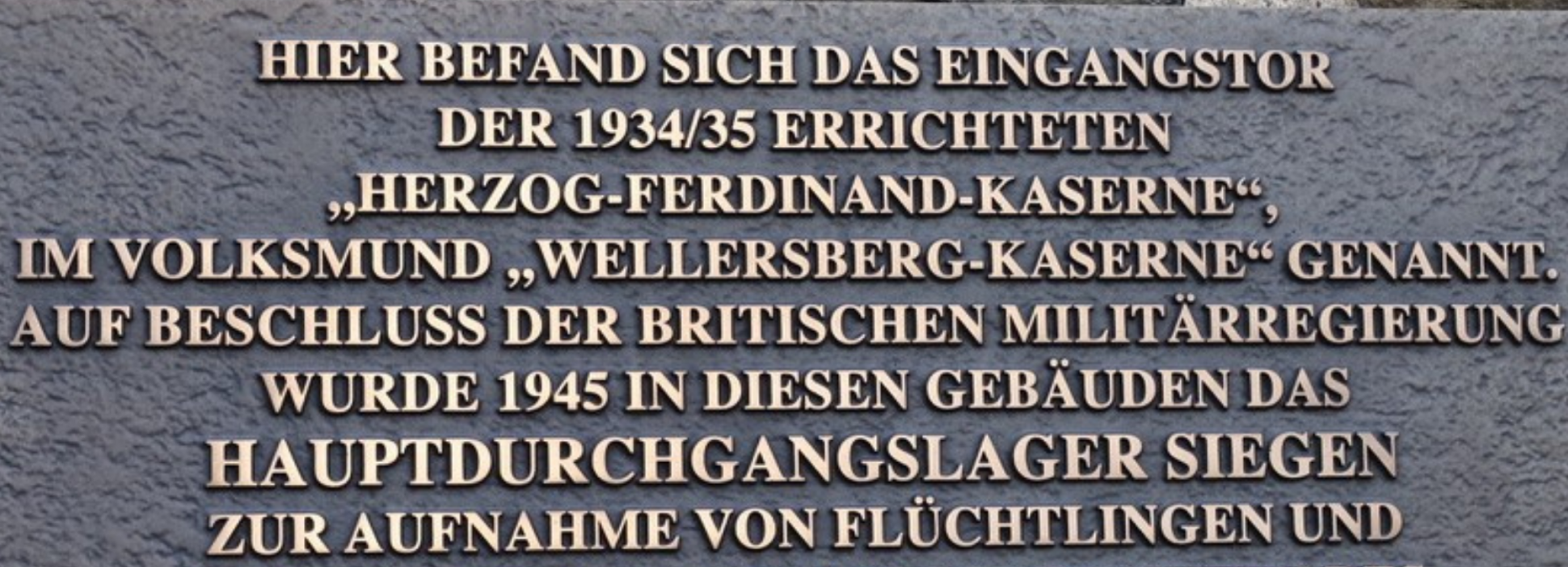 Gedenktafel zur Erinnerung an die Wellersbergkaserne (ab 1938 Herzog-Ferdinand-Kaserne) und das Hauptdurchgangslager Wellersberg (1945/1946 bis 1951) an den restaurierten Fragmenten des früheren Haupteingangsportals, Foto: Stadt Siegen