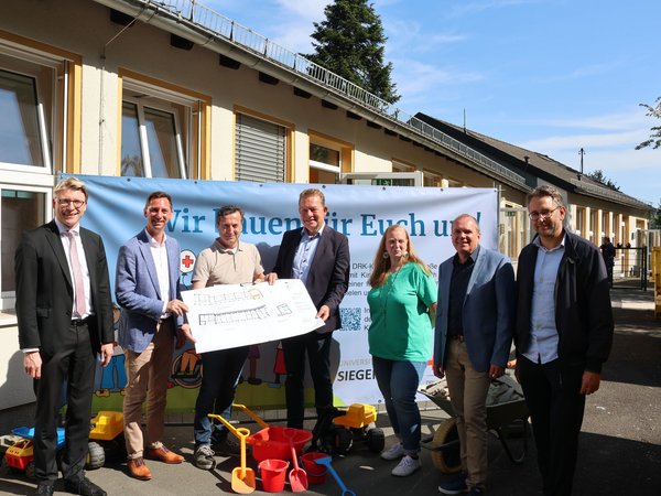 Zum Baustart in der DRK-Kita Breitscheidstraße waren Martin Horchler (DRK), Andreas Müller (DRK), Kamil Polat (TGW), Bürgermeister Steffen Mues, Kita-Leiterin Sabine Krumm, Andree Schmidt (Sozialdezernent) und Henrik Schumann (Stadtbaurat) (v.l.) vor Ort. (Foto: Stadt Siegen)