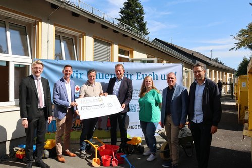 Zum Baustart in der DRK-Kita Breitscheidstraße waren Martin Horchler (DRK), Andreas Müller (DRK), Kamil Polat (TGW), Bürgermeister Steffen Mues, Kita-Leiterin Sabine Krumm, Andree Schmidt (Sozialdezernent) und Henrik Schumann (Stadtbaurat) (v.l.) vor Ort. (Foto: Stadt Siegen)