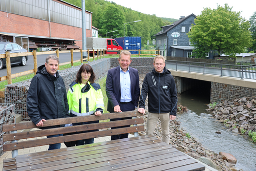 Stephan Roth (ESi), Renate Brühl (ESi-Projektleiterin), Bürgermeister Steffen Mues und Björn Winter (Planungsbüro BauPlan) (v.l.) an der neuen Sitzgruppe neben dem renaturierten Eisernbach. (Foto: Stadt Siegen)