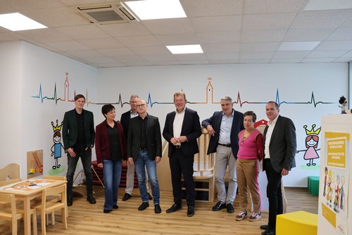 Die städtischen Akteure aus der Kinder-, Jugend- und Familienförderung, NRW-Staatssekretär Lorenz Bahr (3.v.r.) und Bürgermeister Steffen Mues (4.v.r.) vor der Preisübergabe im Familienbüro in Weidenau. (Foto: Stadt Siegen)