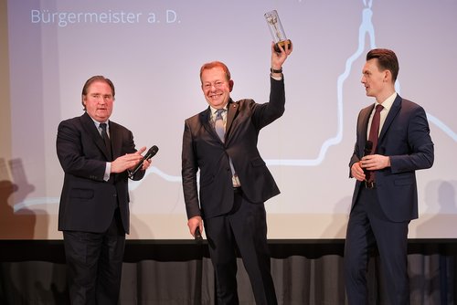 "Glänzender" Auftritt: Steffen Mues erhielt das "Goldene Krönchen" für seine Lebensleistung von Bürgermeister Tristan Vitt (r.), die Laudatio hielt Lutz Lienenkämper. (Foto: Stadt Siegen)
