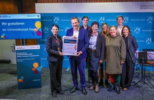 Familienministerin Josefine Paul (l.) überreichte Bürgermeister Steffen Mues und dem Team aus Siegen die Siegerurkunde als „Familienfreundliche Kommune 2025“. (Foto: R. Oberhäuser | MKJFGFI)