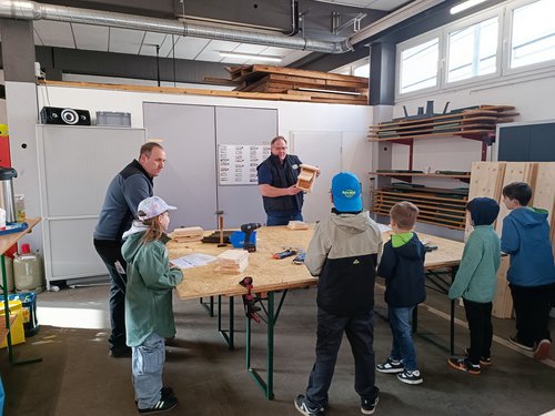 Wie baut man einen Nistkasten? Freiwillige Helfer erklären einen Bauabschnitt. (Foto: Stadt Siegen)