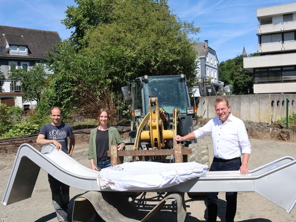 Die Rutsche wird demnächst aufgebaut: (v.l.) Björn Becker, Bauleiter des zuständigen Garten- und Landschaftsbauunternehmens, Projektleiterin Sandra Bruckert sowie Bürgermeister Steffen Mues.(Foto: Stadt Siegen)