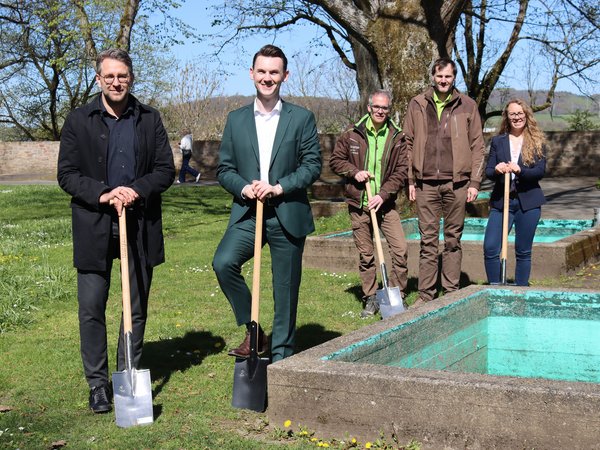 Im Vordergrund: Bürgermeister Tristan Vitt (rechts) und Stadtbaurat Henrik Schumann (links), im Hintergrund zwei Mitarbeiter einer Gartenbau-Fachfirma und Projektleiterin Natascha Klöckner. Die Personen stehen auf der Brunnenwiese am Oberen Schloss mit Spaten in der Hand. 