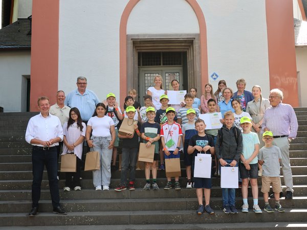Insgesamt 23 Schülerinnen und Schüler der Hubenfeldschule wurden für ihren Einsatz als Schülerlotsinnen und -lotsen von Bürgermeister Steffen Mues (links) geehrt. Urkunden und Freibad-Karten gab es zum Dank. (Foto: Stadt Siegen)