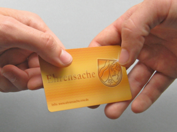 Hände bei Übergabe der Ehrenamtskarte © Staatskanzlei NRW