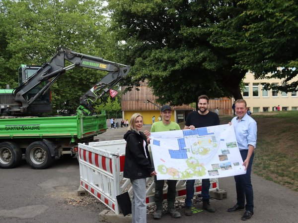 Der Bauplan zeigt viel Grün statt Grau: (v.l.) Projektleiterin Birte Grunwald (TGW), Alexander Achenbach (Garten- und Landschaftsbau), Max Laufenburg (Planungsbüro) und Bürgermeister Steffen Mues bei der Baustellen-Besichtigung an der Jung-Stilling-Schule. (Foto: Stadt Siegen)