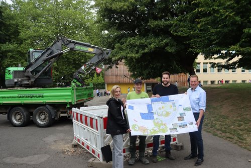 Der Bauplan zeigt viel Grün statt Grau: (v.l.) Projektleiterin Birte Grunwald (TGW), Alexander Achenbach (Garten- und Landschaftsbau), Max Laufenburg (Planungsbüro) und Bürgermeister Steffen Mues bei der Baustellen-Besichtigung an der Jung-Stilling-Schule. (Foto: Stadt Siegen)