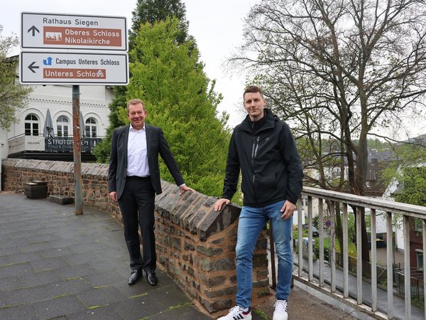 (v.l) Bürgermeister Steffen Mues und Projektleiter Dennis Schuppener von der Straßen- und Verkehrsabteilung vor der neu sanierten Stadtmauer am Löhrtor. (Foto: Stadt Siegen)
