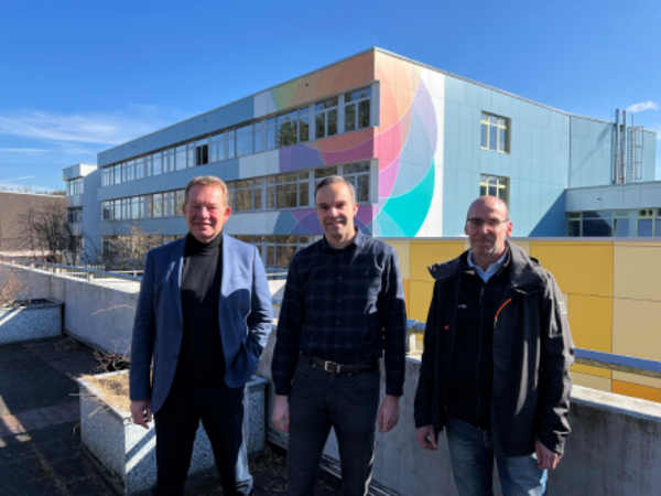 Sind von der farbenfrohen Fassade begeistert: (v.l.) Bürgermeister Steffen Mues, Florian Kraft, Schulleiter der Gesamtschule Am Rosterberg und Andreas Hau, zuständiger Architekt der Technischen Gebäudewirtschaft der Stadt Siegen. (Foto: Stadt Siegen)