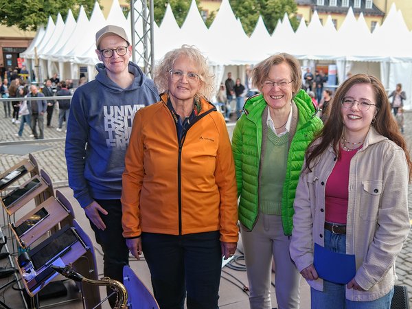 Auf der Bühne: Uni-Pressesprecher André Zeppenfeld, Siegens stellvertretende Bürgermeisterin Angela Jung, Uni-Rektorin Prof. Dr. Stefanie Reese und Moderatorin Anna Lena Schmidt (v.l.) (Foto: Universität Siegen)