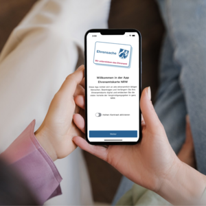 Abbildung eines Smartphones mit der App »Ehrenamtskarte NRW«
