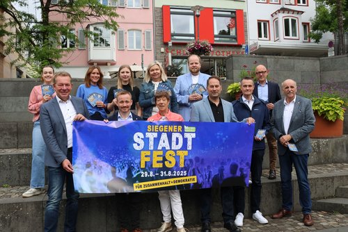 Vorfreude auf das diesjährige Stadtfest: Bürgermeister Steffen Mues (links) und die Verantwortlichen. Partner und Sponsoren. Untere Reihe (v. l.): Bürgermeister Steffen Mues, Sebastian Quast/Bauunternehmen Otto Quast, Astrid Schneider/KulturSiegen, Stadtrat Arne Fries, Stephan Boch und Gerhard Bettermann/beide VWS. Obere Reihe: Nives Carstensen/KulturSiegen, Daniela Hilgendorff/Familienbüro Stadt Siegen, Carla Wiesener/ SVB, Tanja Herdlitschke/Sparkasse Siegen, Patrick Plate/Westenergie, Michael Göttert/Siegener Zeitung (Medienpartner). (Foto: Stadt Siegen)