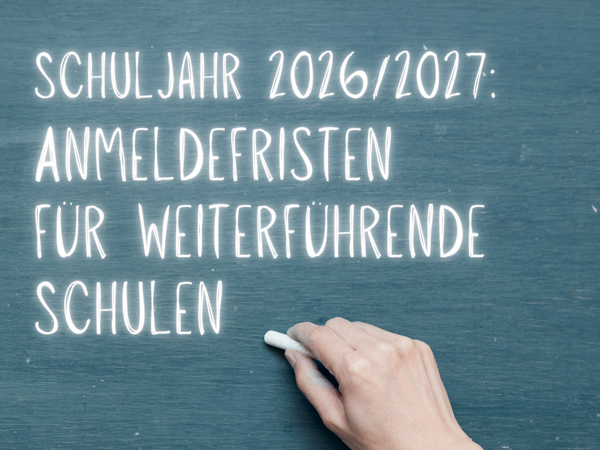 Auf dem Bild sieht man eine grüne Schreibtafel, auf der mit weißer Kreide der Text "Schuljahr 2026/2027: Anmeldefristen für weiterführende Schulen" geschrieben steht. Eine Hand hält ein Stück Kreide am unteren rechten Rand.