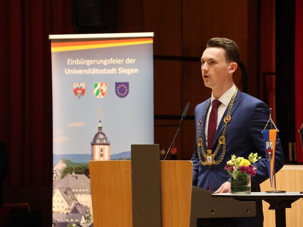 Bürgermeister Tristan Vitt begrüßte die über 80 neuen Staatsbürgerinnen und Staatsbürger in der Bismarckhalle. (Foto: Stadt Siegen)