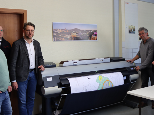 Michael Krämer (Abteilung Vermessung), Thomas Jung (Koordinator SAE), Henrik Schumann (Leiter SAE), Ralf Hensel (Repro-Stelle) und Bürgermeister Steffen Mues in der städtischen Repro-Stelle im Geisweid Rathaus. (Foto: Stadt Siegen)