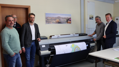 Michael Krämer (Abteilung Vermessung), Thomas Jung (Koordinator SAE), Henrik Schumann (Leiter SAE), Ralf Hensel (Repro-Stelle) und Bürgermeister Steffen Mues in der städtischen Repro-Stelle im Geisweid Rathaus. (Foto: Stadt Siegen)