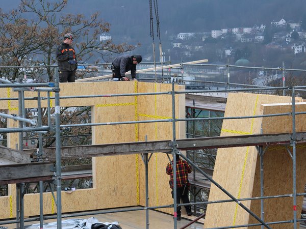 Arbeiter bringen eine Wand auf dem Gebäude an