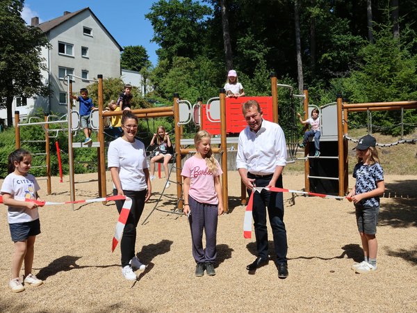 Die Schülerinnen und Schüler der Albert-Schweitzer-Schule haben den Spielplatz gemeinsam mit Manuela Haas, Leiterin der städtischen Grünflächenabteilung und Bürgermeister Steffen Mues eröffnet und direkt ausprobiert. (Foto: Stadt Siegen)
