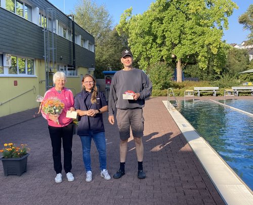 Margret Henß (l.) und Martin Müller (r.) erhalten die beiden Hauptpreise von Katharina Sierpinski (Betriebsleitung Freibad Kaan-Marienborn). (Foto: Stadt Siegen)