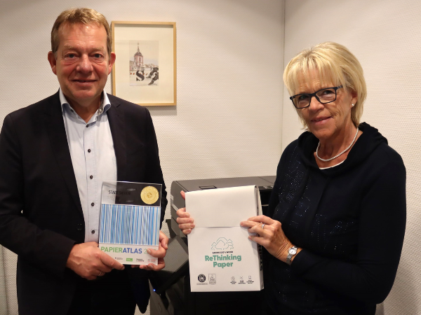 Bürgermeister Steffen Mues und Regina Stiller, Mitarbeiterin im Büro Bürgermeister, nahmen stellvertretend für die Stadt Siegen die Auszeichnung als „Mehrfachsieger“ für die konsequente Nutzung von Recyclingpapier entgegen. (Foto: Stadt Siegen)
