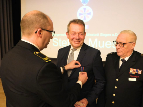 Thomas Jung (l.) überreichte Steffen Mues, Bürgermeister a.D., die Feuerwehr-Ehrenmedaille. (Foto: Stadt Siegen)