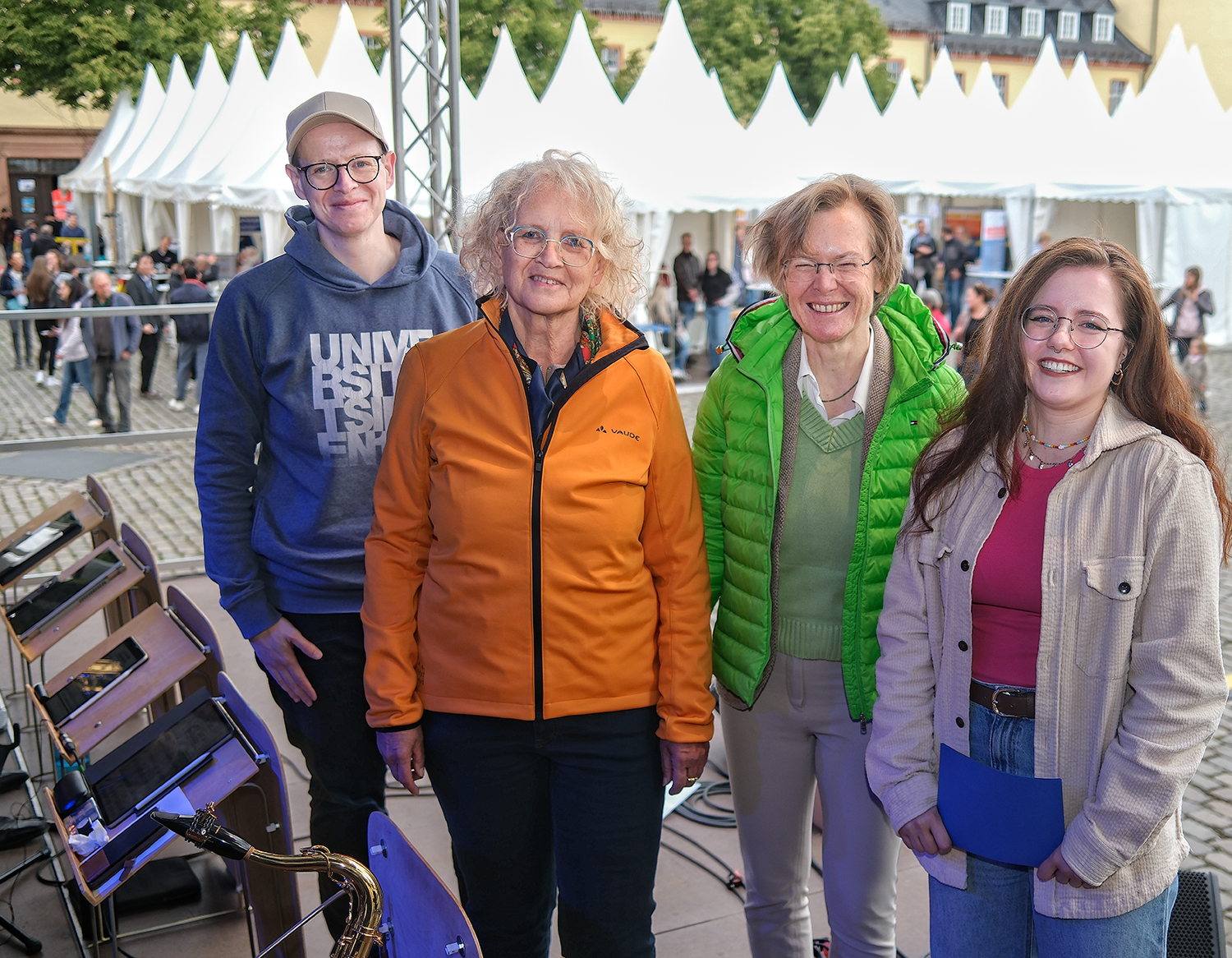Auf der Bühne: Uni-Pressesprecher André Zeppenfeld, Siegens stellvertretende Bürgermeisterin Angela Jung, Uni-Rektorin Prof. Dr. Stefanie Reese und Moderatorin Anna Lena Schmidt (v.l.) (Foto: Universität Siegen)